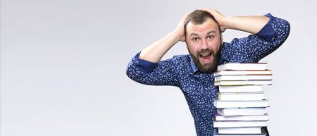 75676350 - an adult student with a stack of books