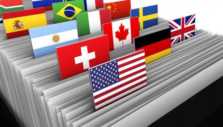International business and global market concept with a close-up of a customer file directory with document and some international flags on tags.